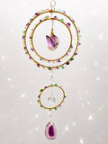 a vibrant handcrafted triple-ring design featuring a beautiful medium-sized raw Amethyst cluster suspended at its centre as the focal point of the piece.